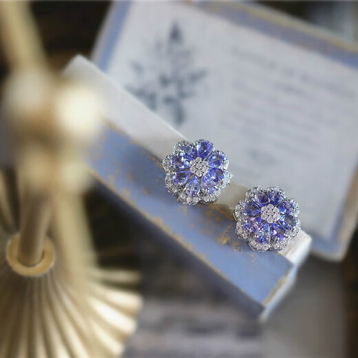 A pair of 925 silver stud earrings inlaid with multiple tanzanites, set against a sea of dazzling flowers and galaxies. A pair of stud earrings.