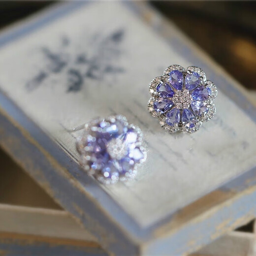 A pair of 925 silver stud earrings inlaid with multiple tanzanites, set against a sea of dazzling flowers and galaxies. A pair of stud earrings.