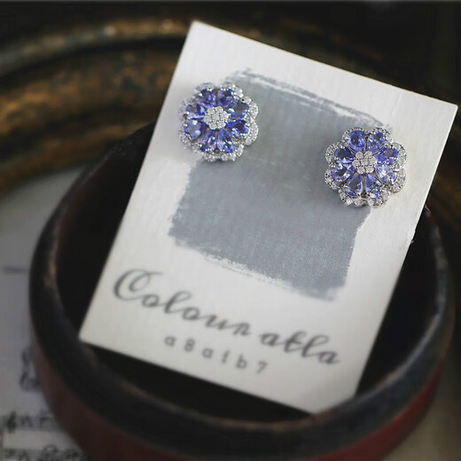 A pair of 925 silver stud earrings inlaid with multiple tanzanites, set against a sea of dazzling flowers and galaxies. A pair of stud earrings.