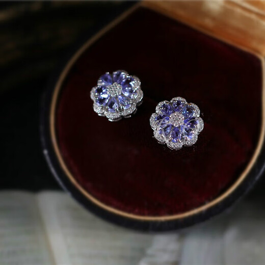 A pair of 925 silver stud earrings inlaid with multiple tanzanites, set against a sea of dazzling flowers and galaxies. A pair of stud earrings.